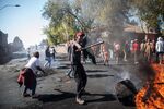 A man waves a stick in front a burning piece of furniture during a riot in the Johannesburg suburb of Turffontein on Sept. 2.