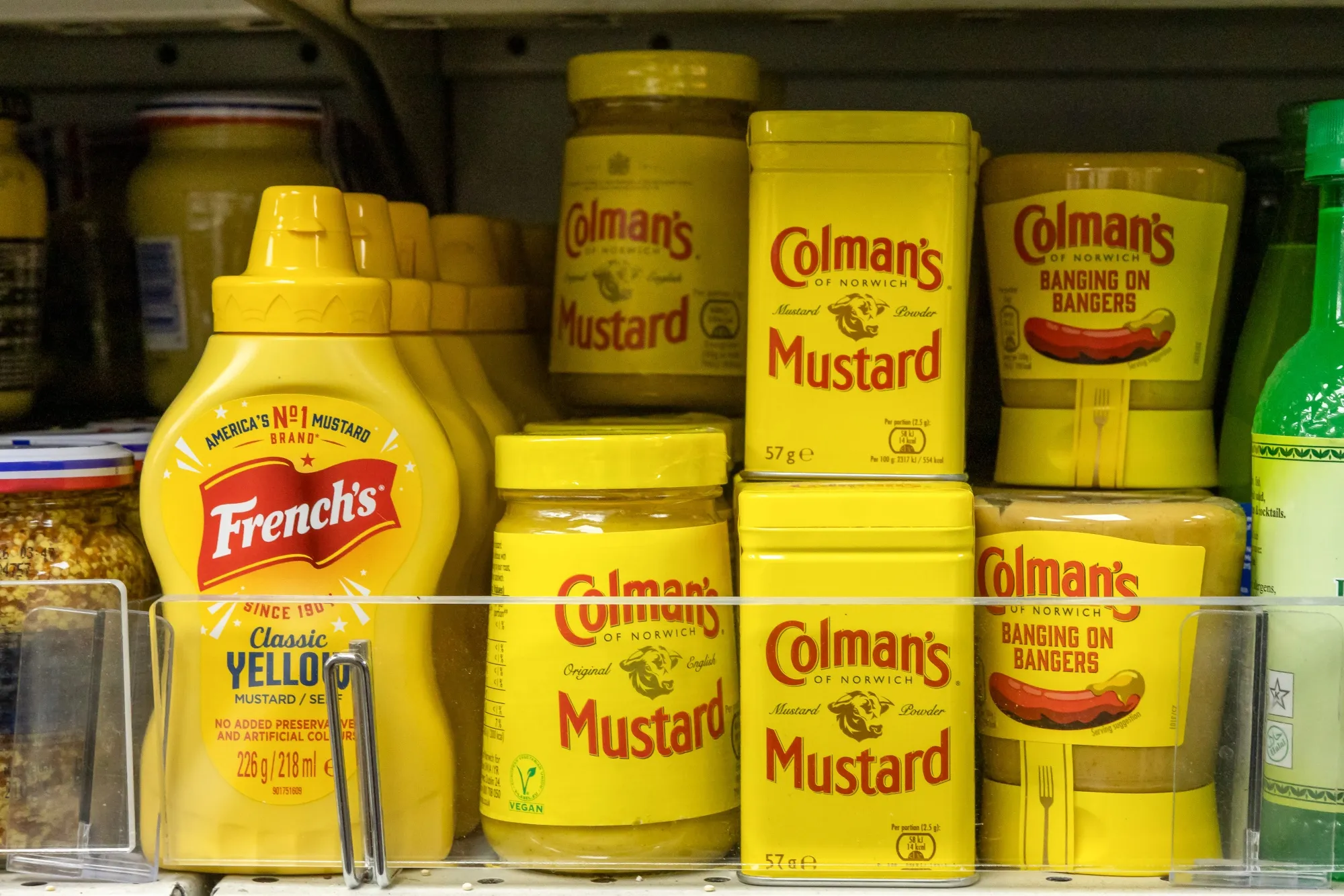 A bottle of Frenchs Classic Yellow mustard and Colmans mustard products on display in a supermarket in London.