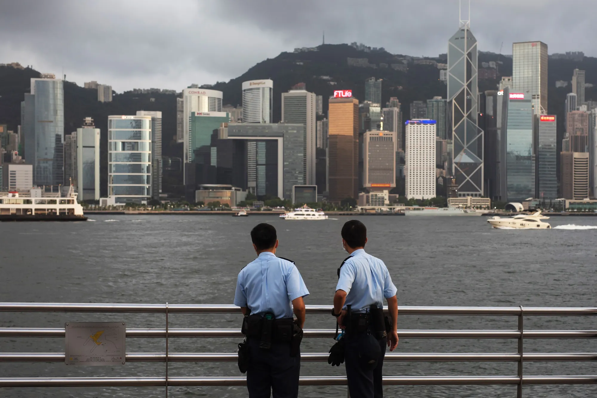 Police officers stand guard in front of the skyline in Hong Kong, China.