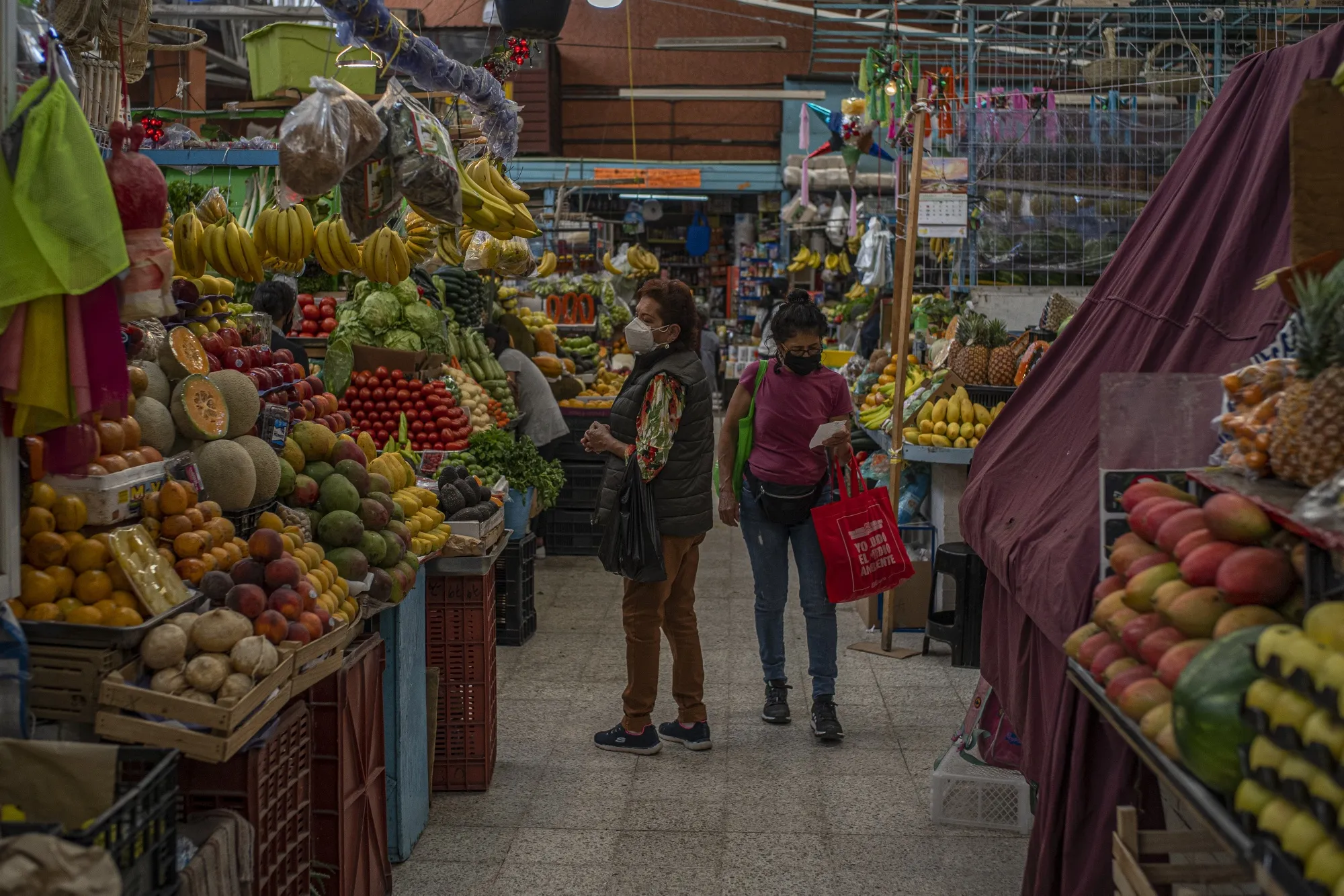 Customers shop for fruits and vegetables at a market in Mexico City.