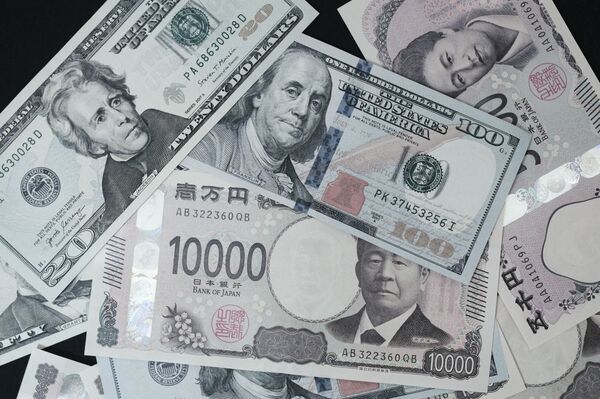 Japanese yen banknote and US dollar banknotes arranged for a photograph in Tokyo, Japan. 