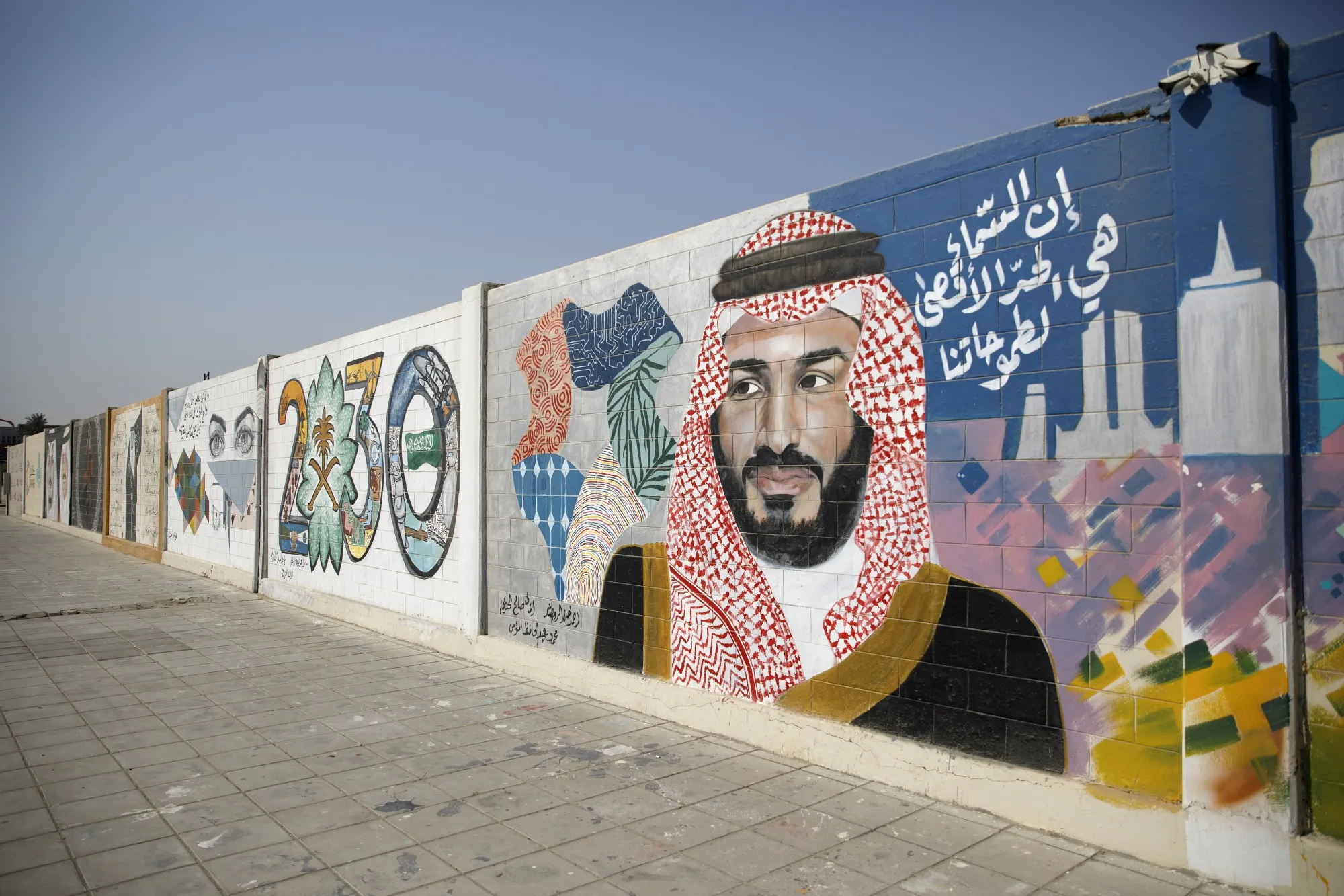 A wall mural displays the '2030 Vision' logo and Saudi Arabia's Crown Prince Mohammed bin Salman in Dhahran.