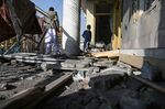 People inspect a damaged house after shells land north west of Kabul on Nov. 21.
