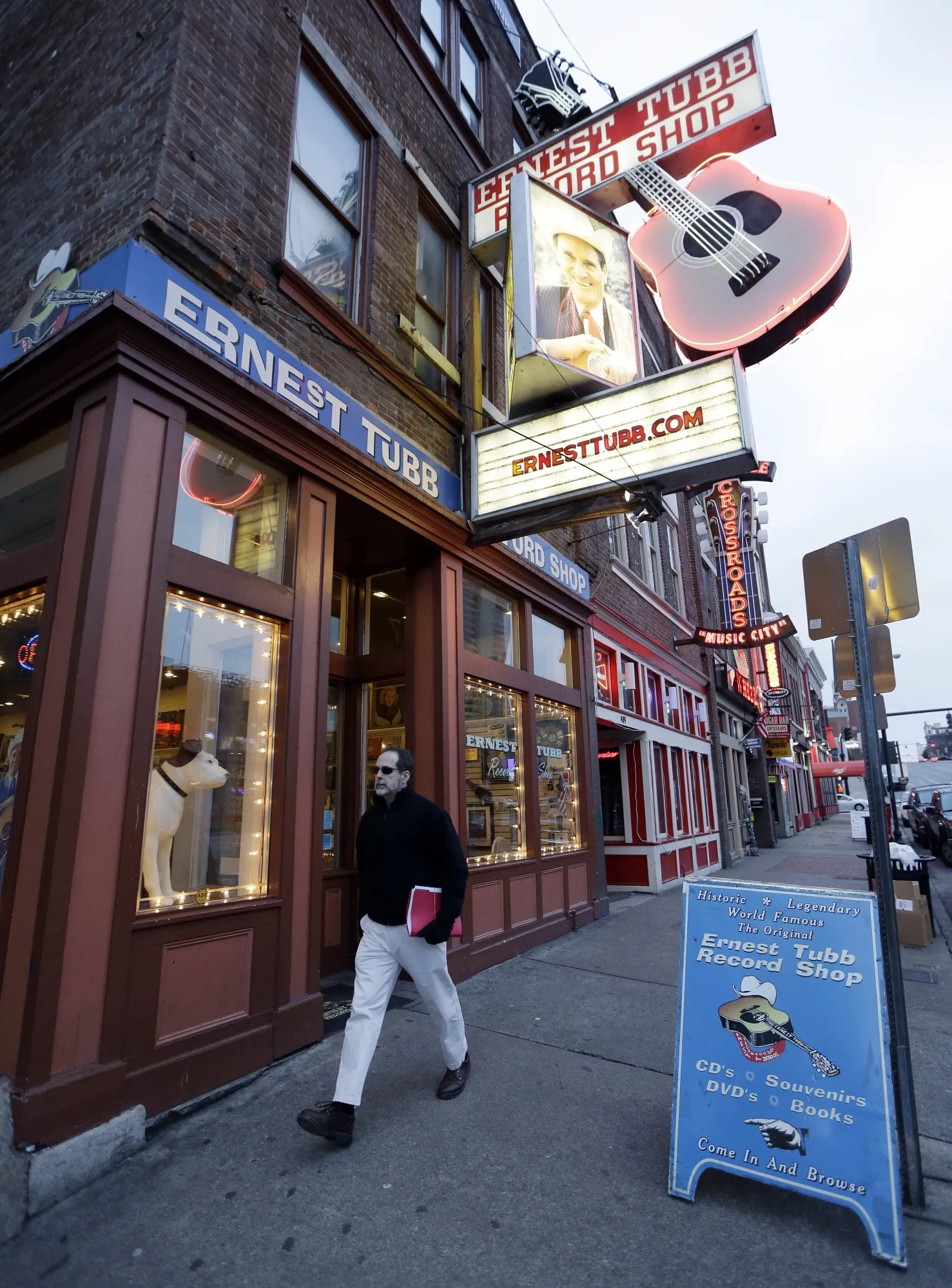 A pedestrian walks by the Ernest Tubb Record Shop in Nashville, Tenn., on Jan. 15, 2014. The Nashville record store that was opened by Opry legend Ernest Tubb in 1947 will close as the building is being put up for sale. Owners announced on Friday that the shop on Broadway will close in the spring after being in its current location since 1951, citing circumstances “beyond our control.” (AP Photo/Mark Humphrey, File)