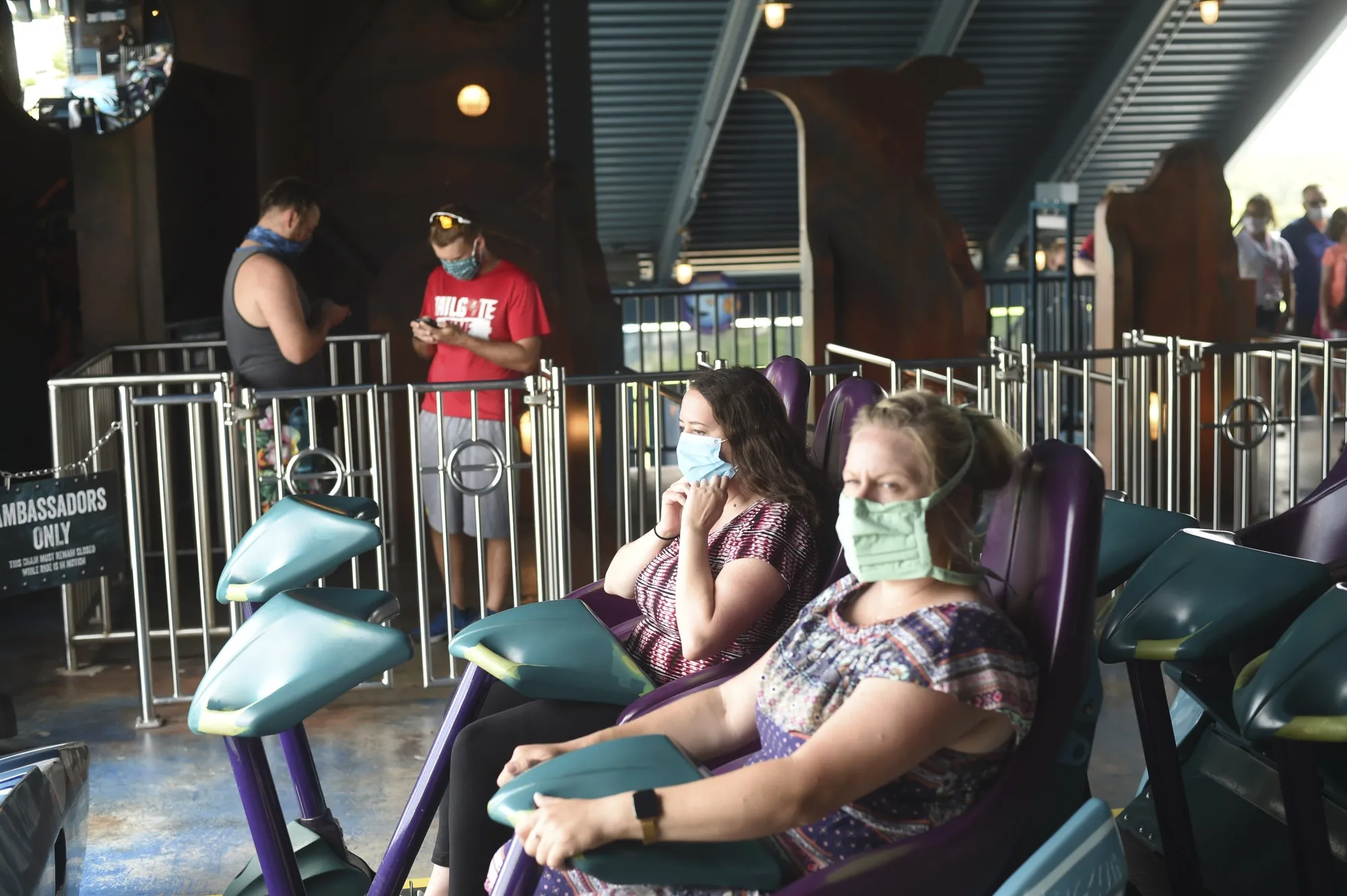 Visitors wear protective masks while sitting on a roller coaster at the SeaWorld amusement park in Orlando, Florida,&nbsp;on&nbsp;June 11.