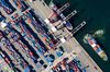 A tug boat pulls a container ship as shipping containers sit in the Busan Port Terminal (BPT) at the Port of Busan in this aerial photograph taken in Busan, South Korea, on Tuesday, July 30, 2019. A trade dispute between South Korea and Japan is threatening to spiral out of control, and both governments want the White House on their side.