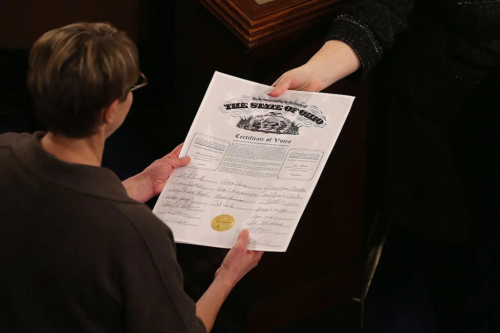 Congressional clerks pass the Electoral College certificate from the state of Ohio while unsealing and organizing all the votes from the 50 states in the House of Representatives chamber at the U.S. Capitol January 4, 2013 in Washington, DC.