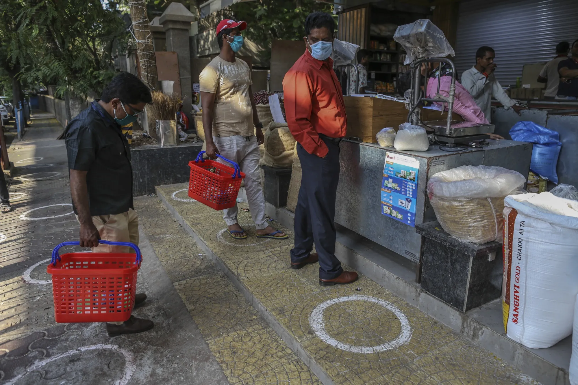 People practice social distancing, indicated by markings on the floor, at a market in Mumbai, April 5.