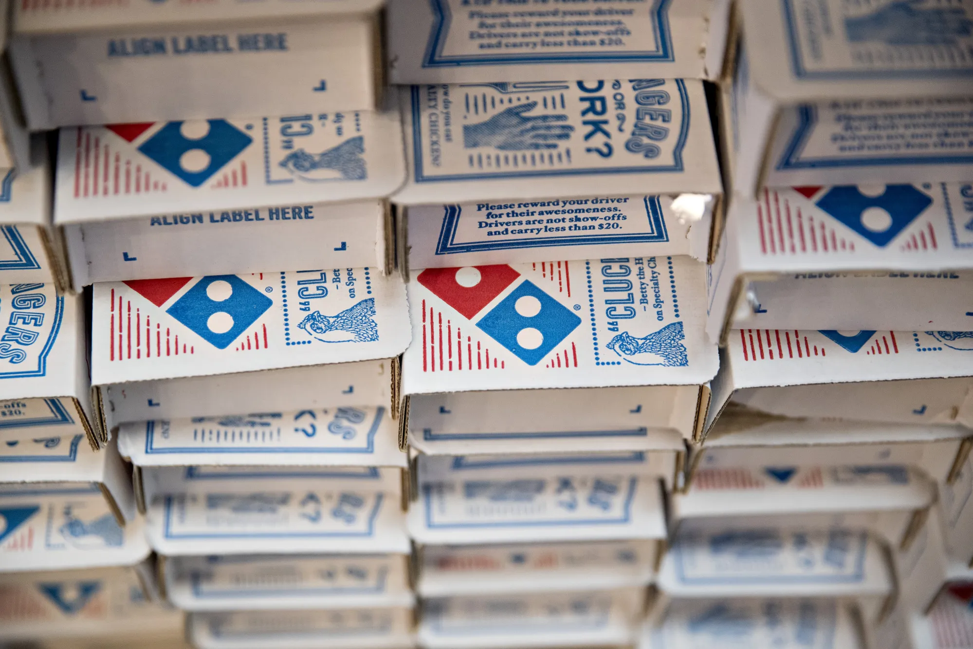 The Domino's logo is seen on boxes at a restaurant.