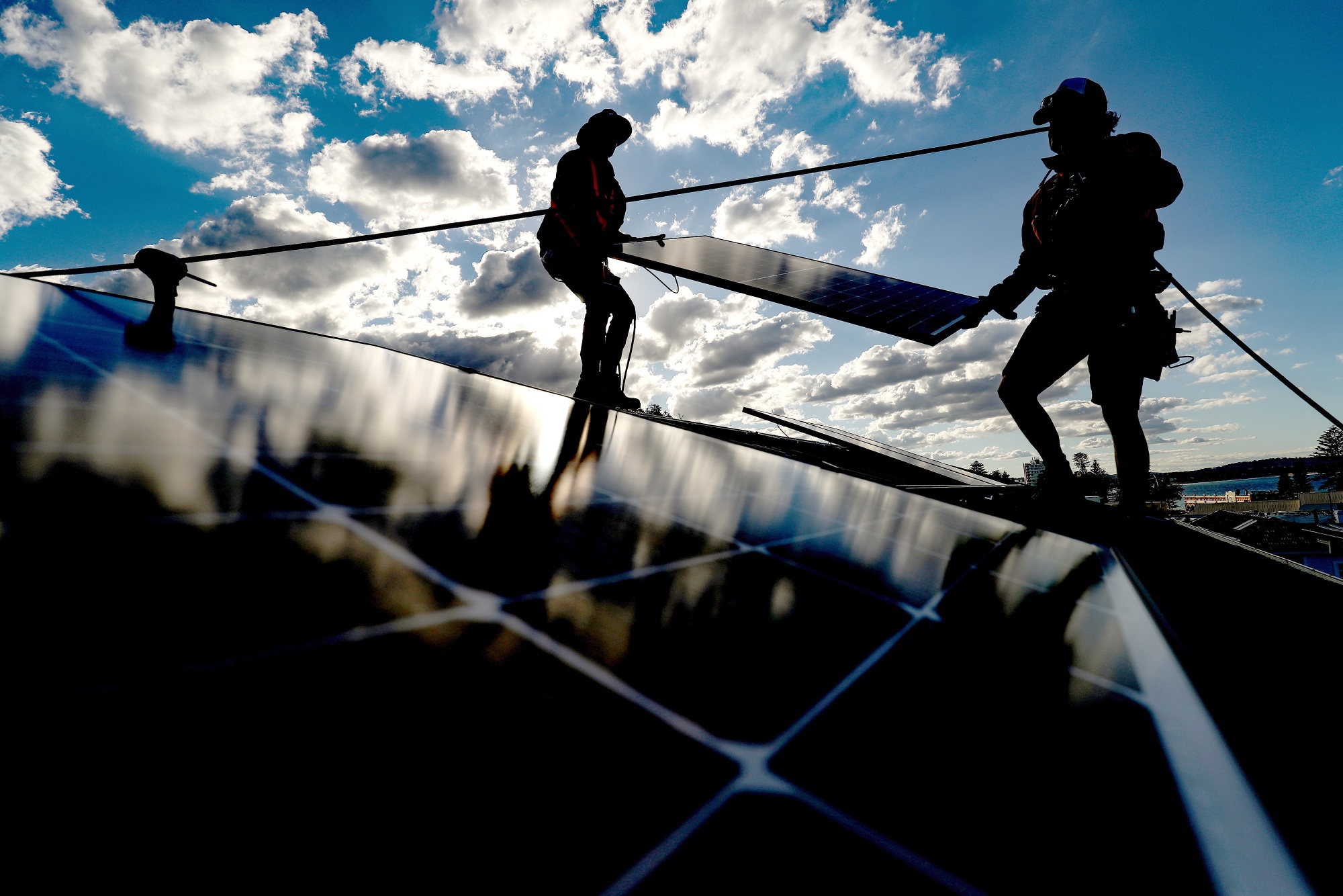Solarpro employees install solar panels onto the rooftop of a residential property in Sydney, Australia.