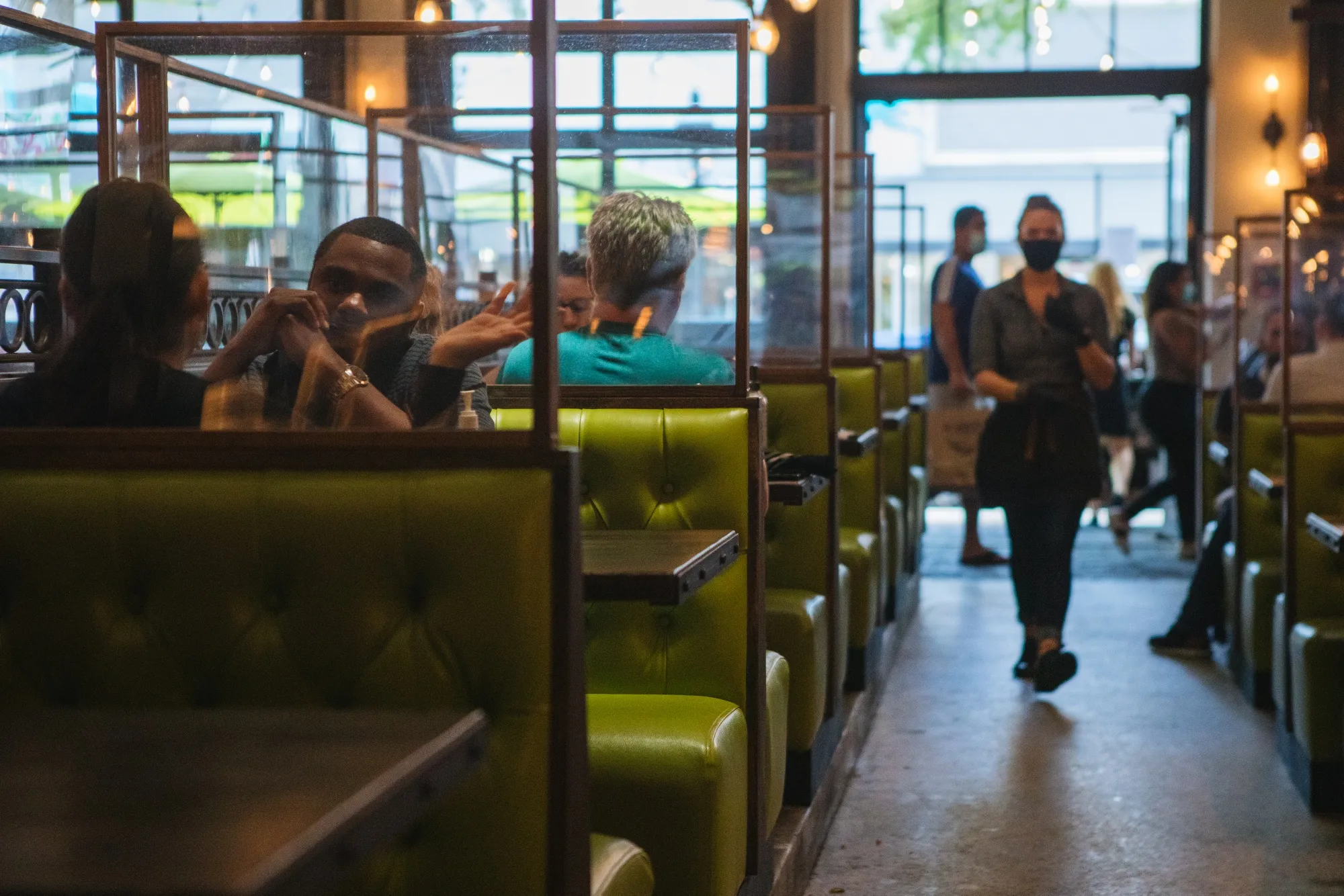 Customers sit at booths separated with plastic protective barriers at a restaurant in Fort Lauderdale, Florida, U.S., on&nbsp;June 25.