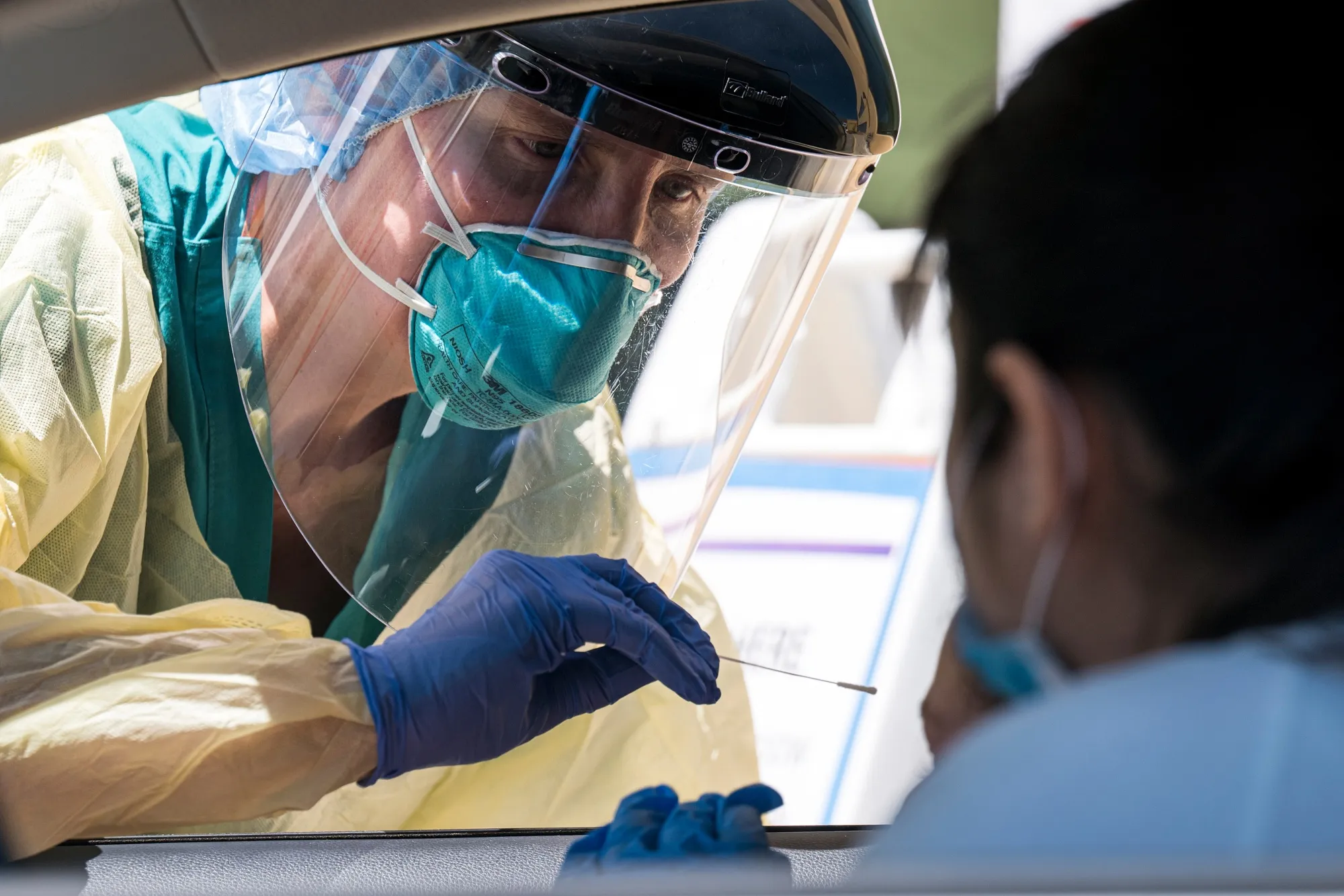 A medical worker administers a swab test at a drive-thru testing site in San Pablo, California on April 28.