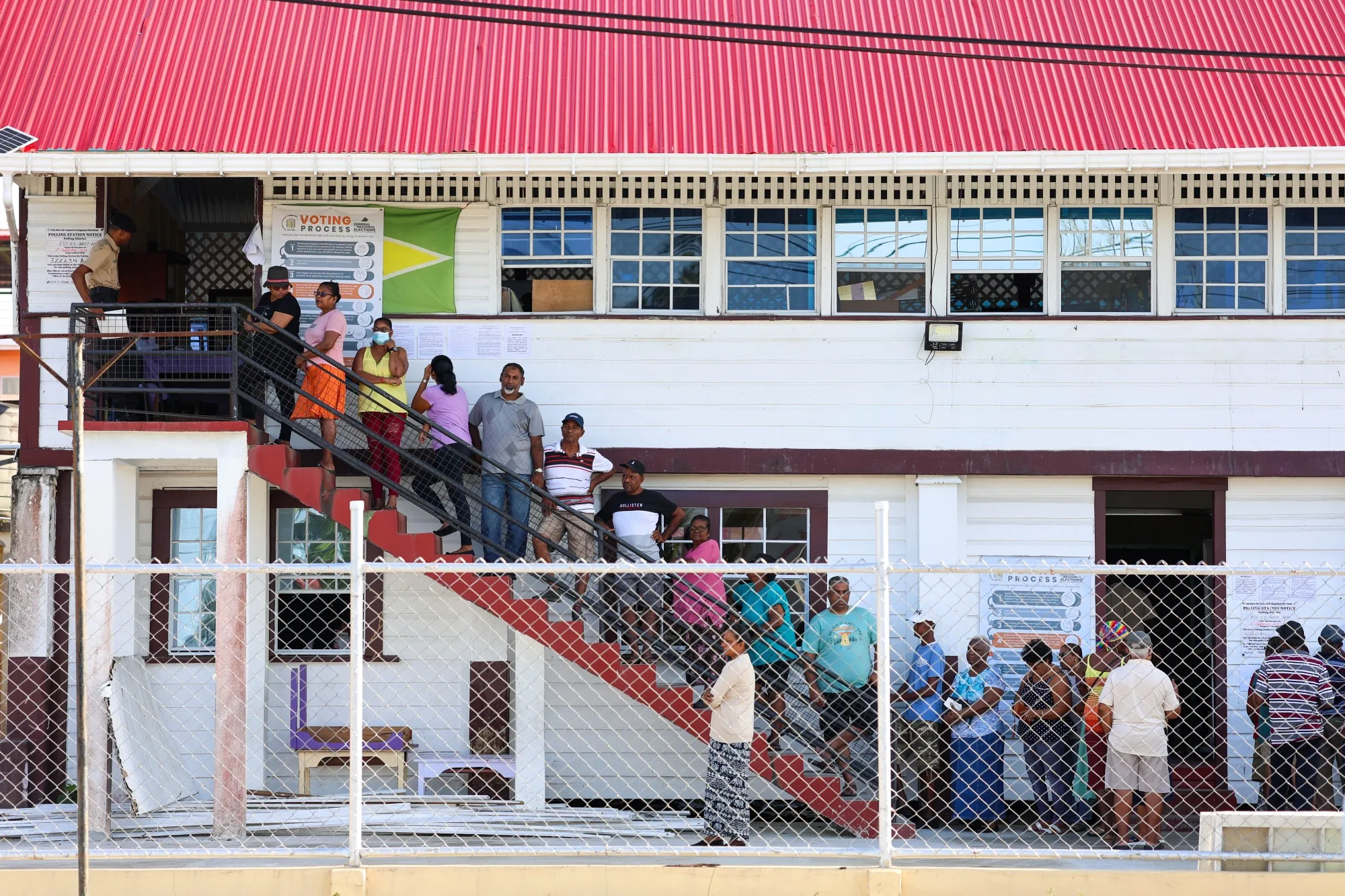 Voters wait in line to cast ballots at a polling location during the general election in Leonora, West Demerara, Guyana.