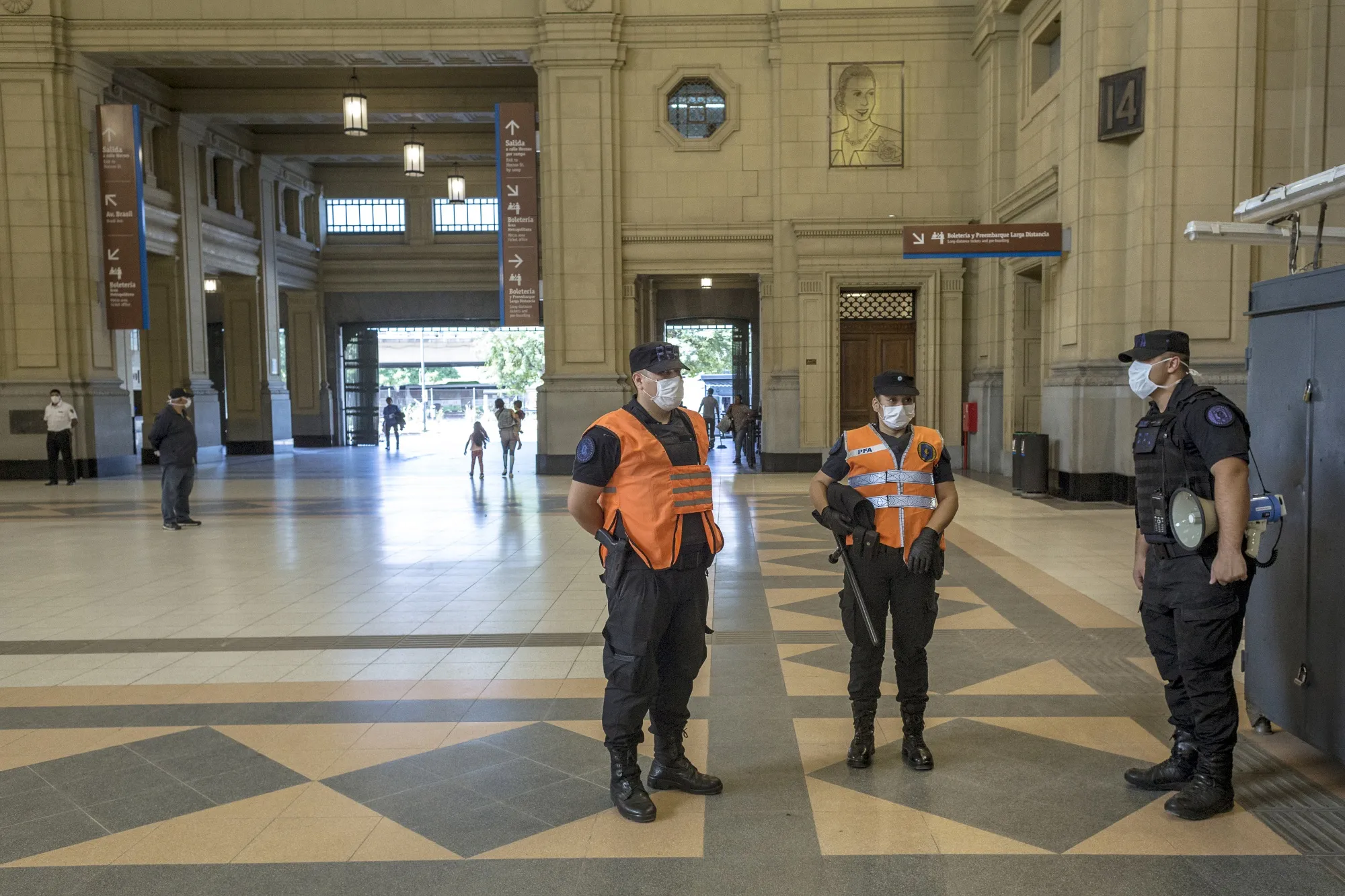 Police officers wearing protective masks stand at a checkpoint at the Constitucion train station in Buenos Aires, Argentina.
