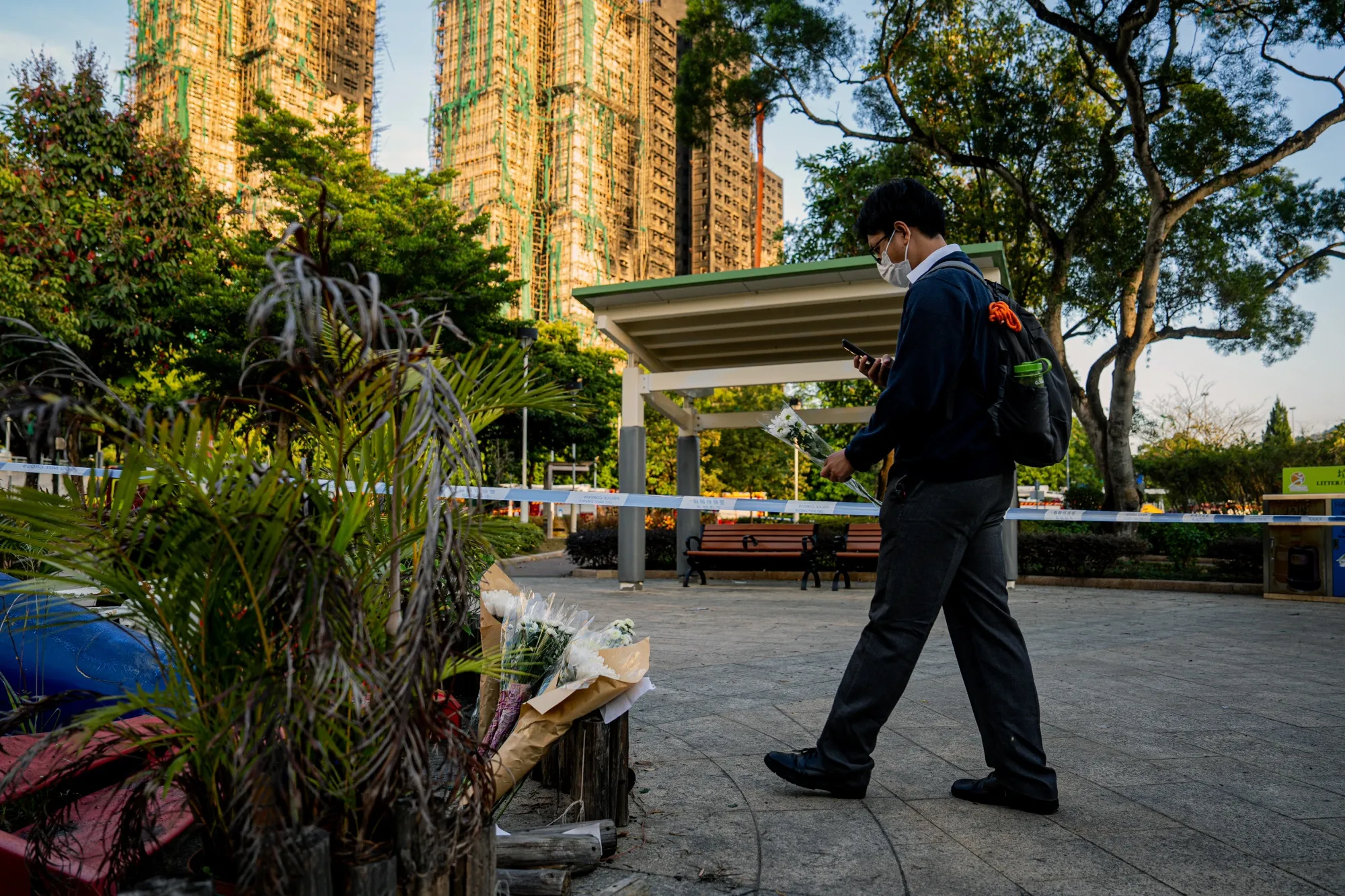 A student brings flowers for victims of the fire at Wang Fuk Court residential estate in Hong Kong on Nov. 28, 2025.