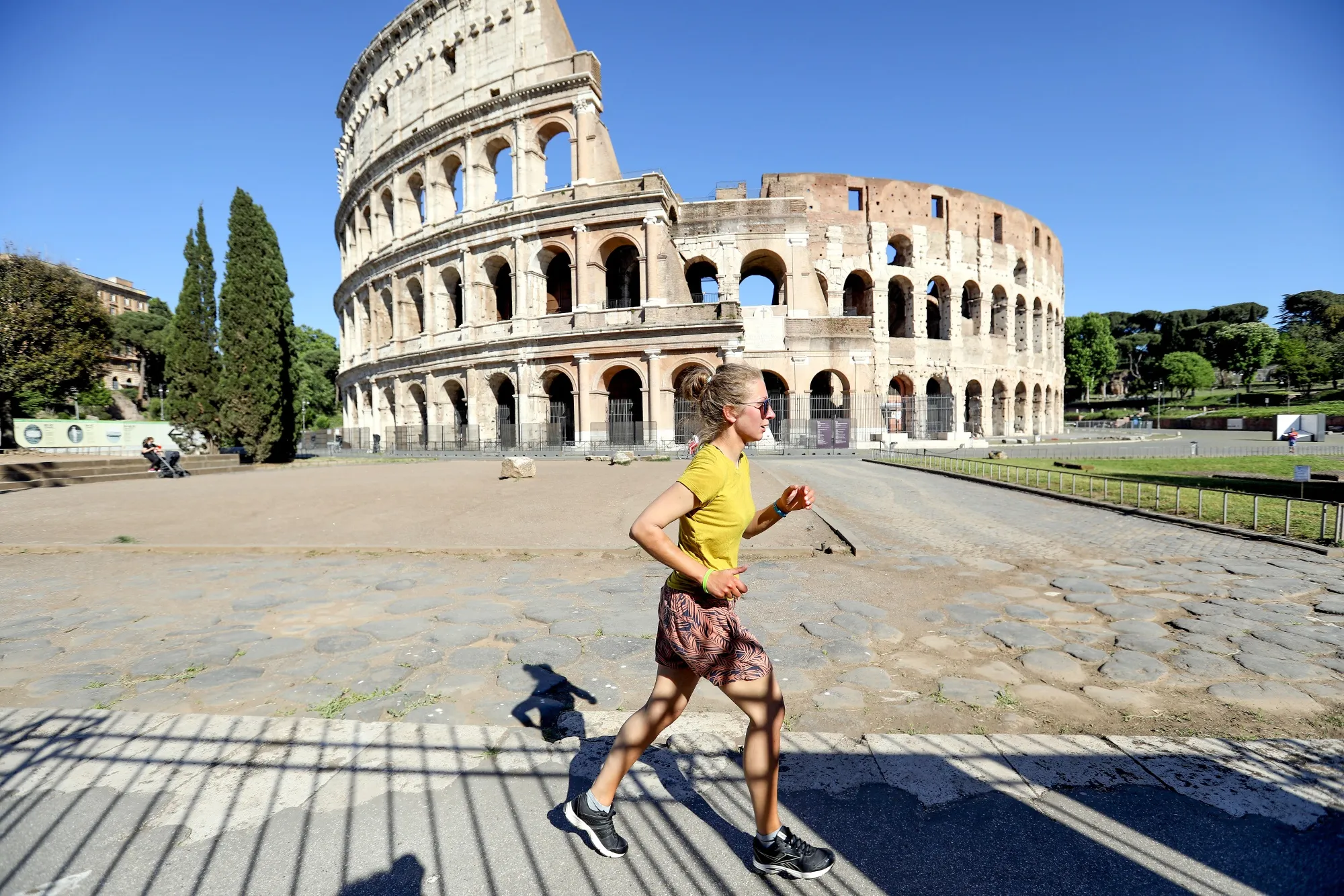 A jogger passes the Colosseum in Rome, Italy