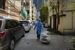 Neighborhood volunteers transport bags of vegetables delivered by the government during lockdown in Shanghai, April 3.