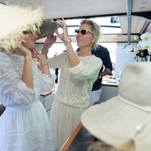 Nicky Tindill helps a guest work a style during a Jonathan Howard from Hatmaker private event aboard her father Sandy Oakley's yacht, Andiamo.