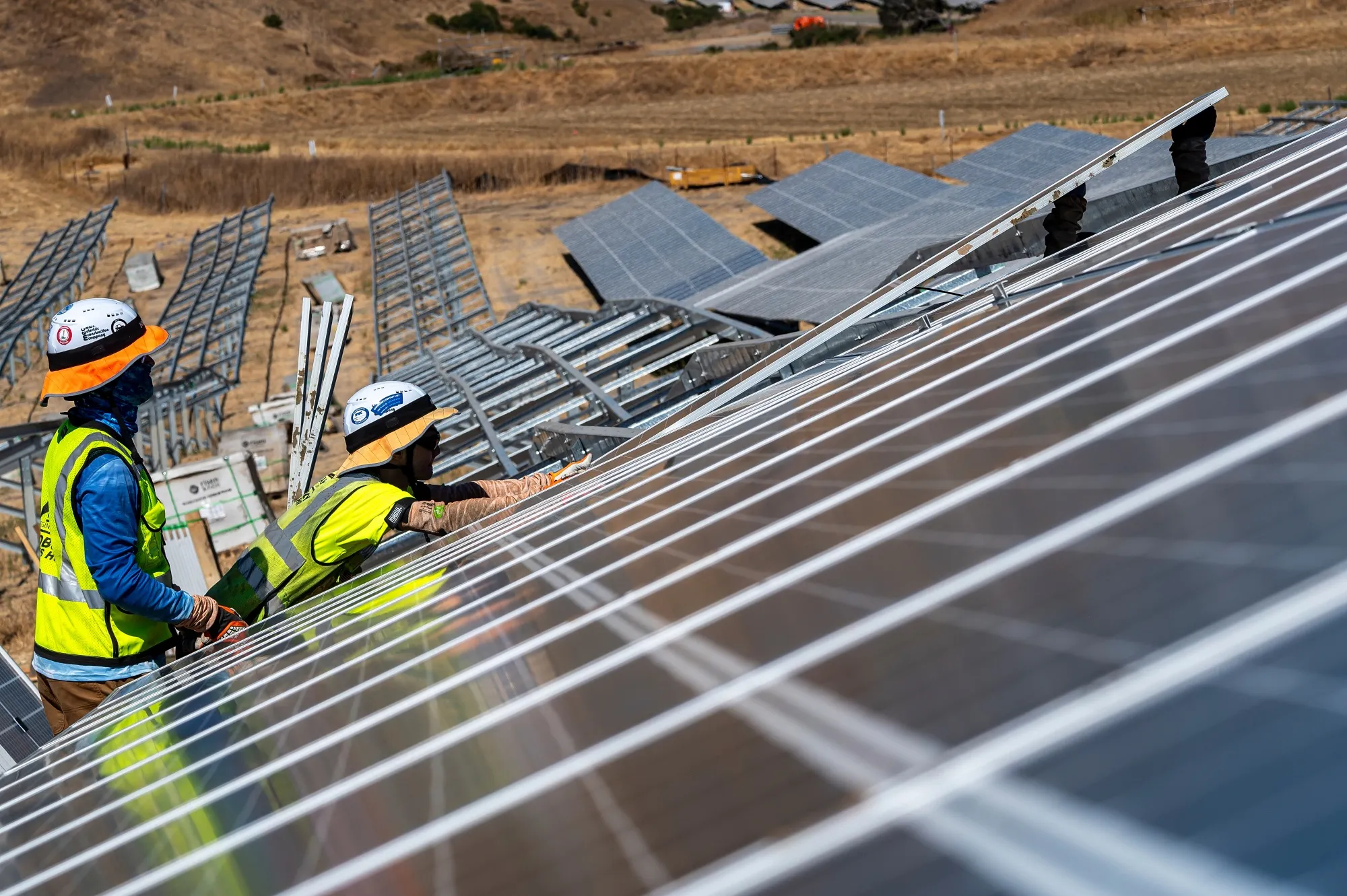 Contractors install solar panels in California.