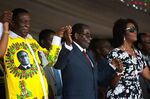 Zimbabwean President Robert Mugabe (C) holds hands with Vice President Emmerson Mnangagwa (L) and First Lady Grace Mugabe (R) during celebrations marking his birthday at the Great Zimbabwe monument in Masvingo on February 27, 2016. / AFP / JEKESAI NJIKIZANA (Photo credit should read JEKESAI NJIKIZANA/AFP/Getty Images)

