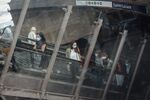 Morning rush hour commuters wear protective face masks while riding escalators at Gare Saint-Lazare railway station in Paris, France.