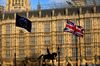 A British Union flag, also known as a Union Jack, flies beside European Union (EU) flags as pedestrians walk outside the Houses of Parliament in London, U.K., on Wednesday, March 27, 2019. U.K. Prime Minister Theresa May addresses the influential 1922 Committee of Tory MPs at 5 p.m.
