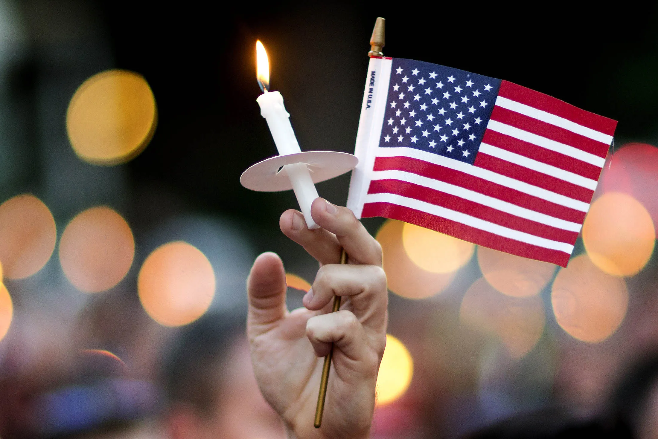 A mourner holds up an American flag and a candle during a vigil in Atlanta on Sunday for victims of the shooting at an Orlando nightclub.
