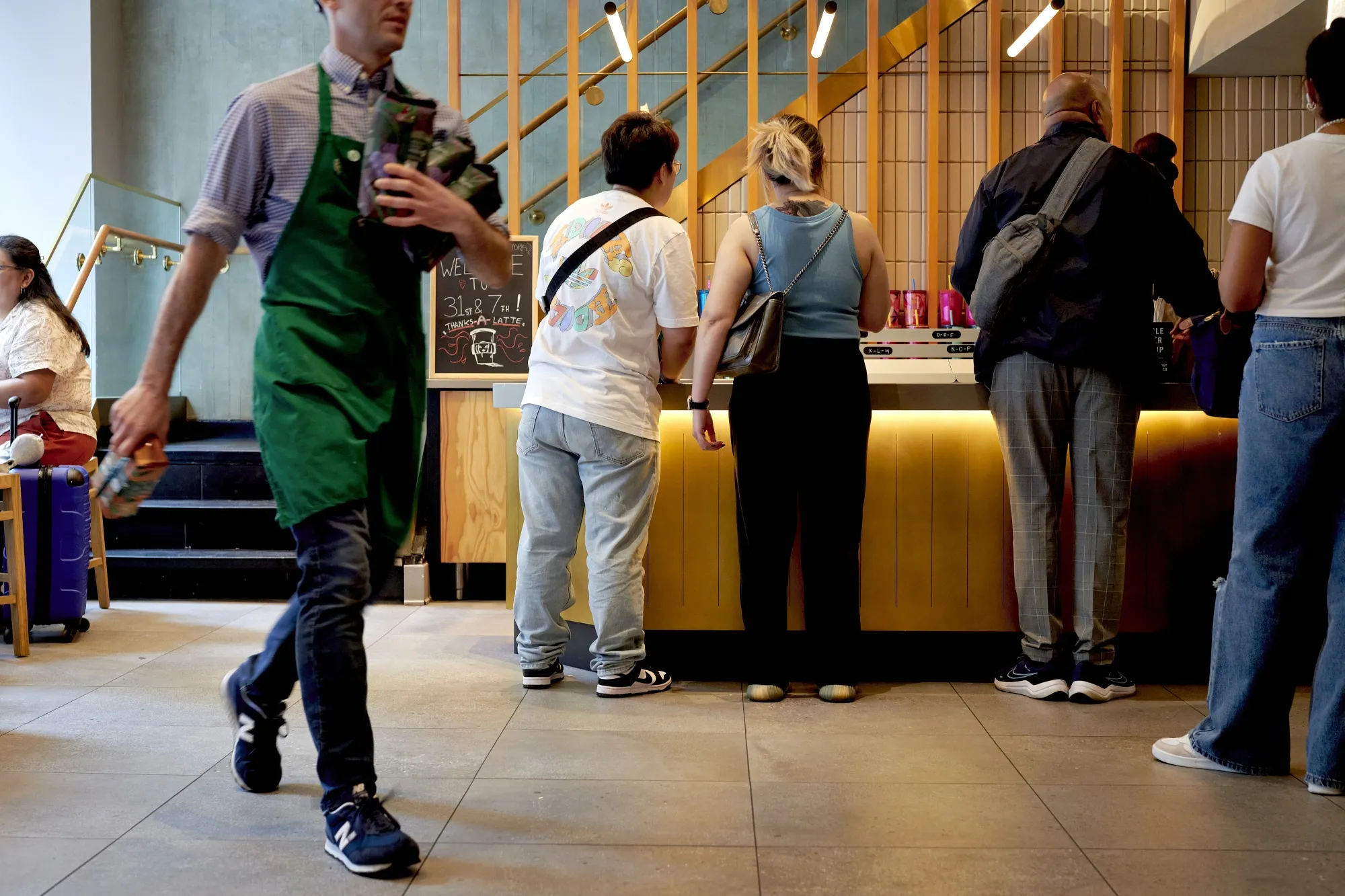 Customers wait to pick up their orders at a Starbucks in New York.