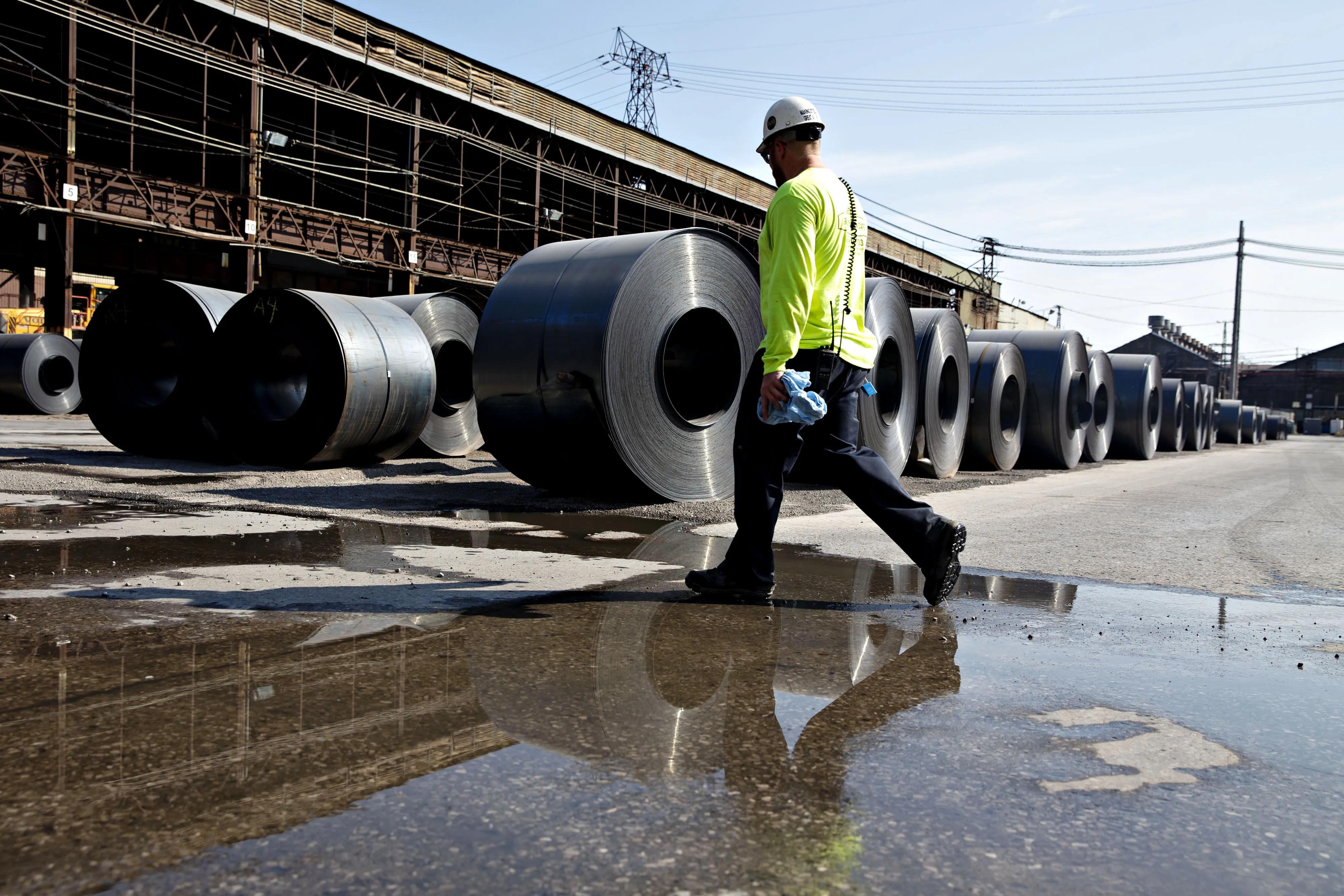 A worker walks past steel coils at the U.S. Steel Corp. Granite City Works facility in Granite City, Illinois, U.S., on Thursday, July 26, 2018.