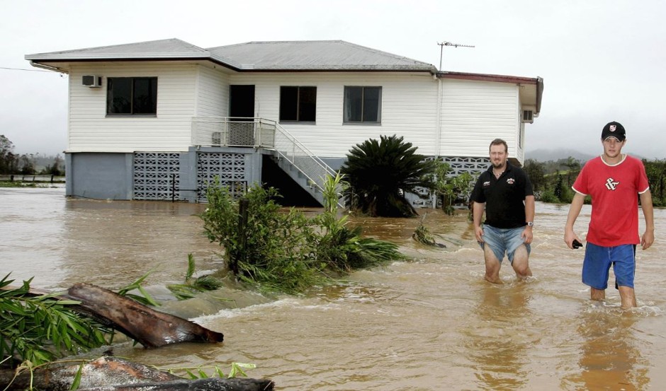 Brothers wade through flood waters in the wake of 2006's Cyclone Larry.