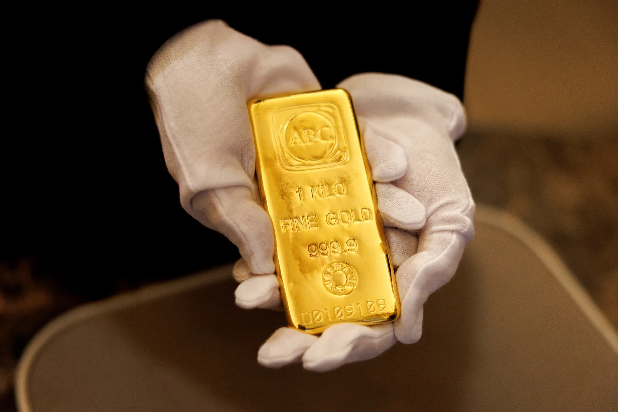 An employee holds a one kilogram gold bar inside an ABC Bullion store in Sydney, Australia.