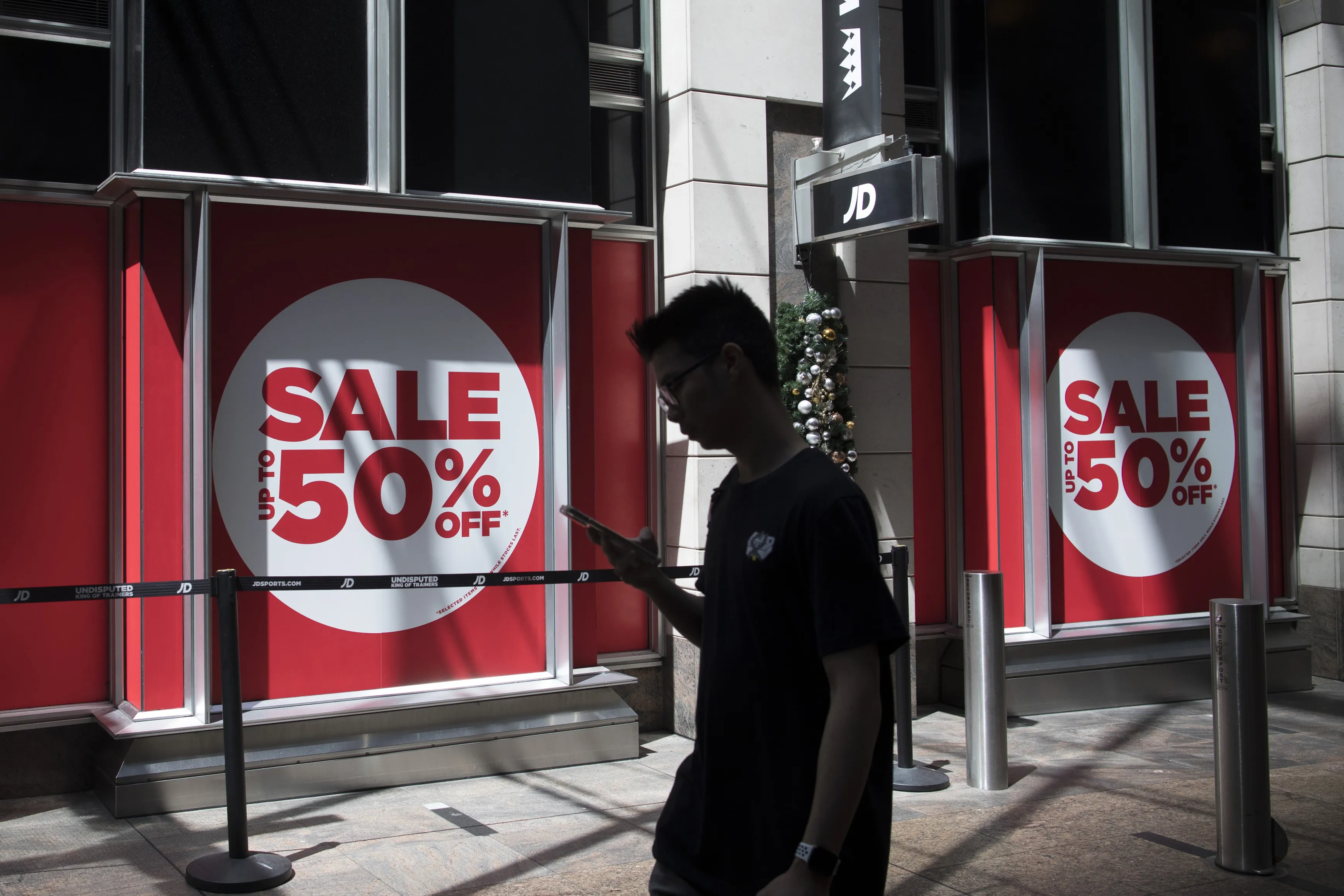 A pedestrian by sale signs in Sydney, New South Wales, Australia.