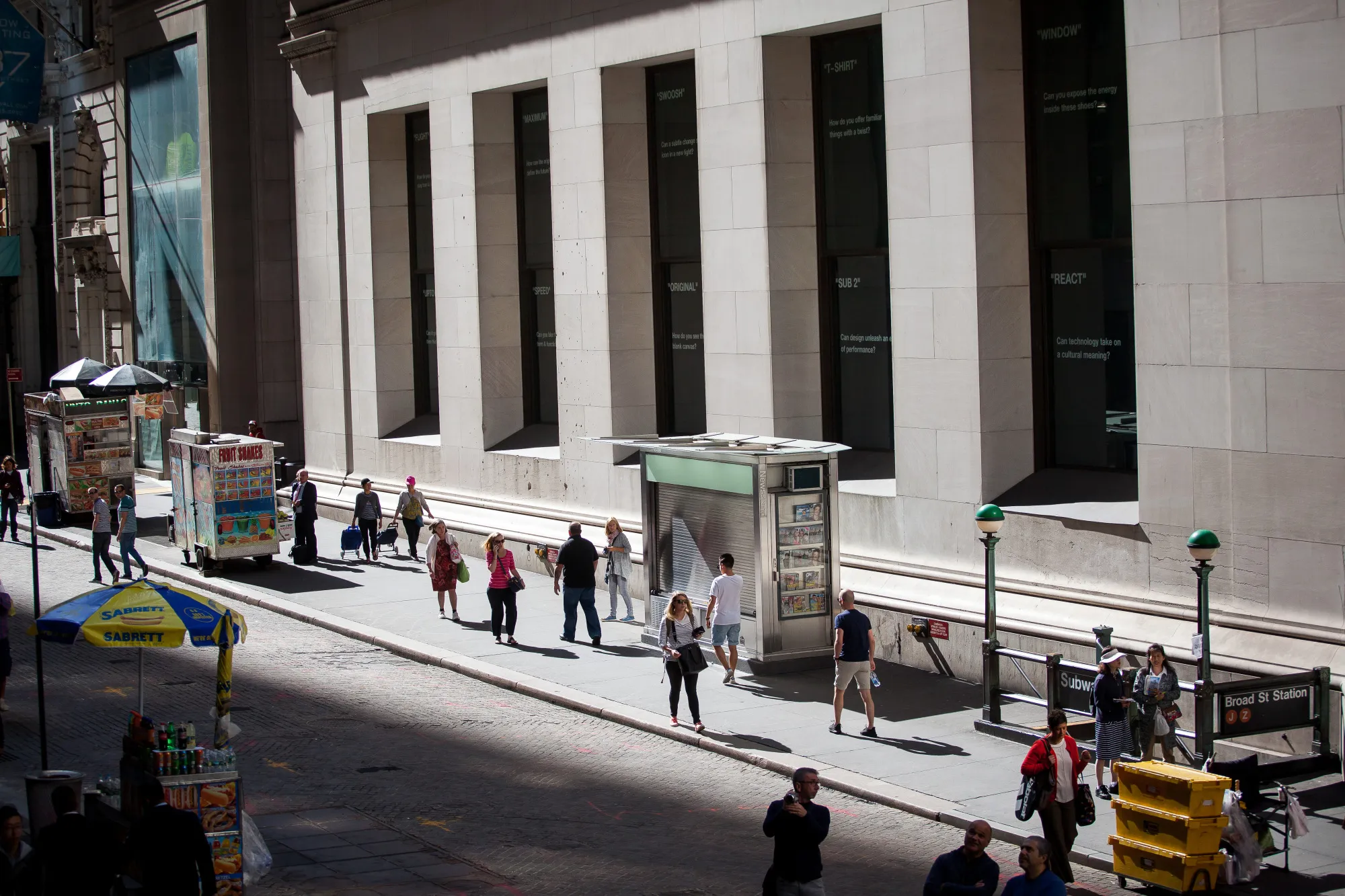 Pedestrians walk along Wall Street near the New York Stock Exchange.