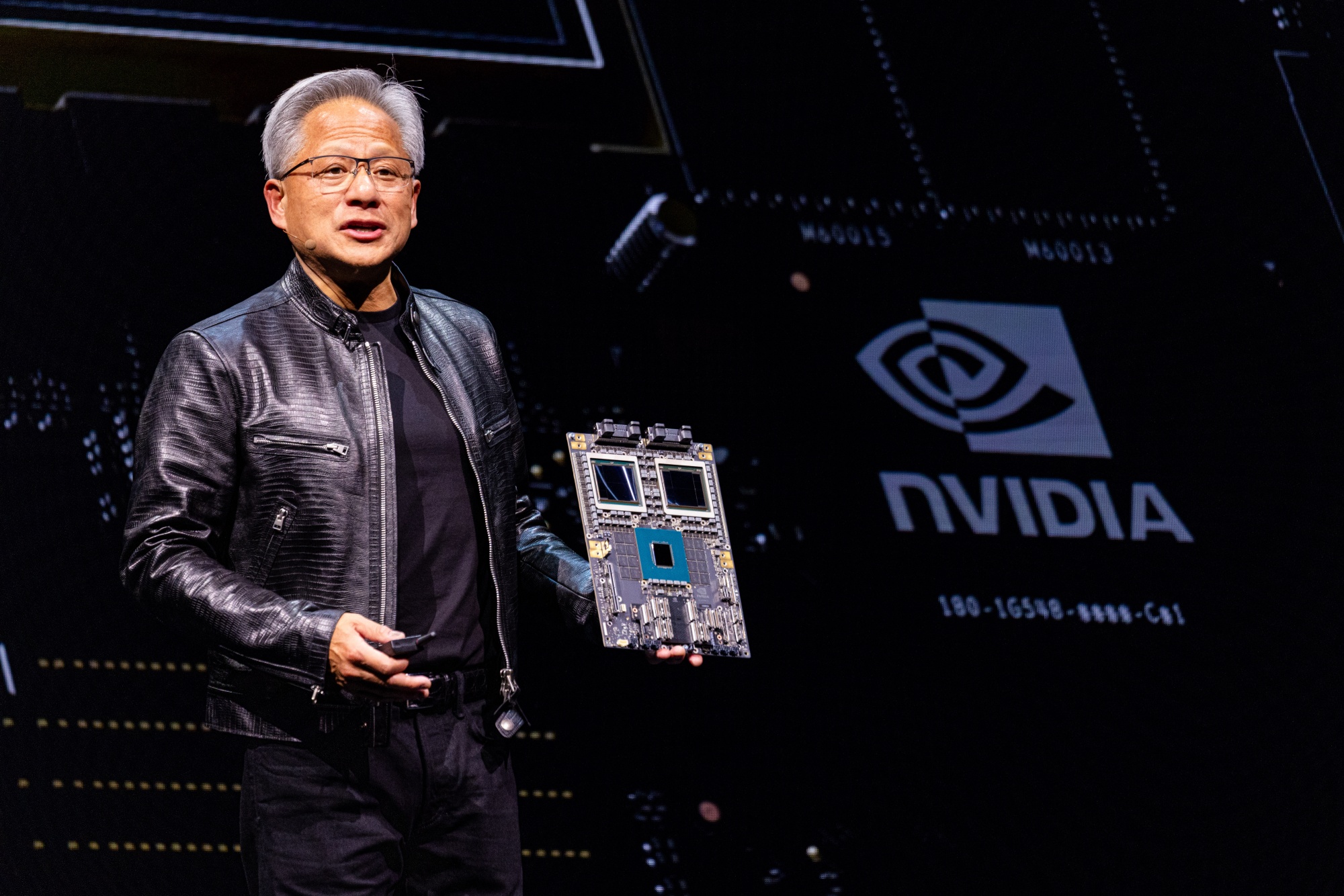 Jensen Huang displays a Blackwell chip during an event in Taipei, Taiwan.