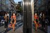 A shop window reflects pedestrians wearing protective face masks on New Bond Street in central London, U.K.