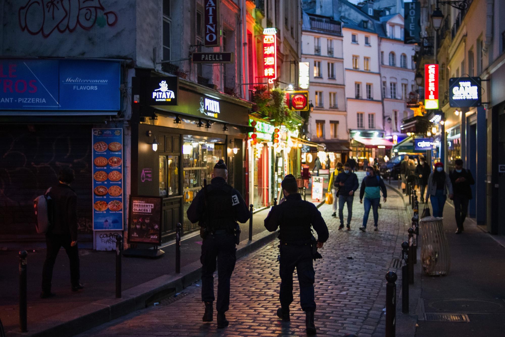 Police patrol near illuminated take away food outlets in Paris, France, on&nbsp;Oct. 6.