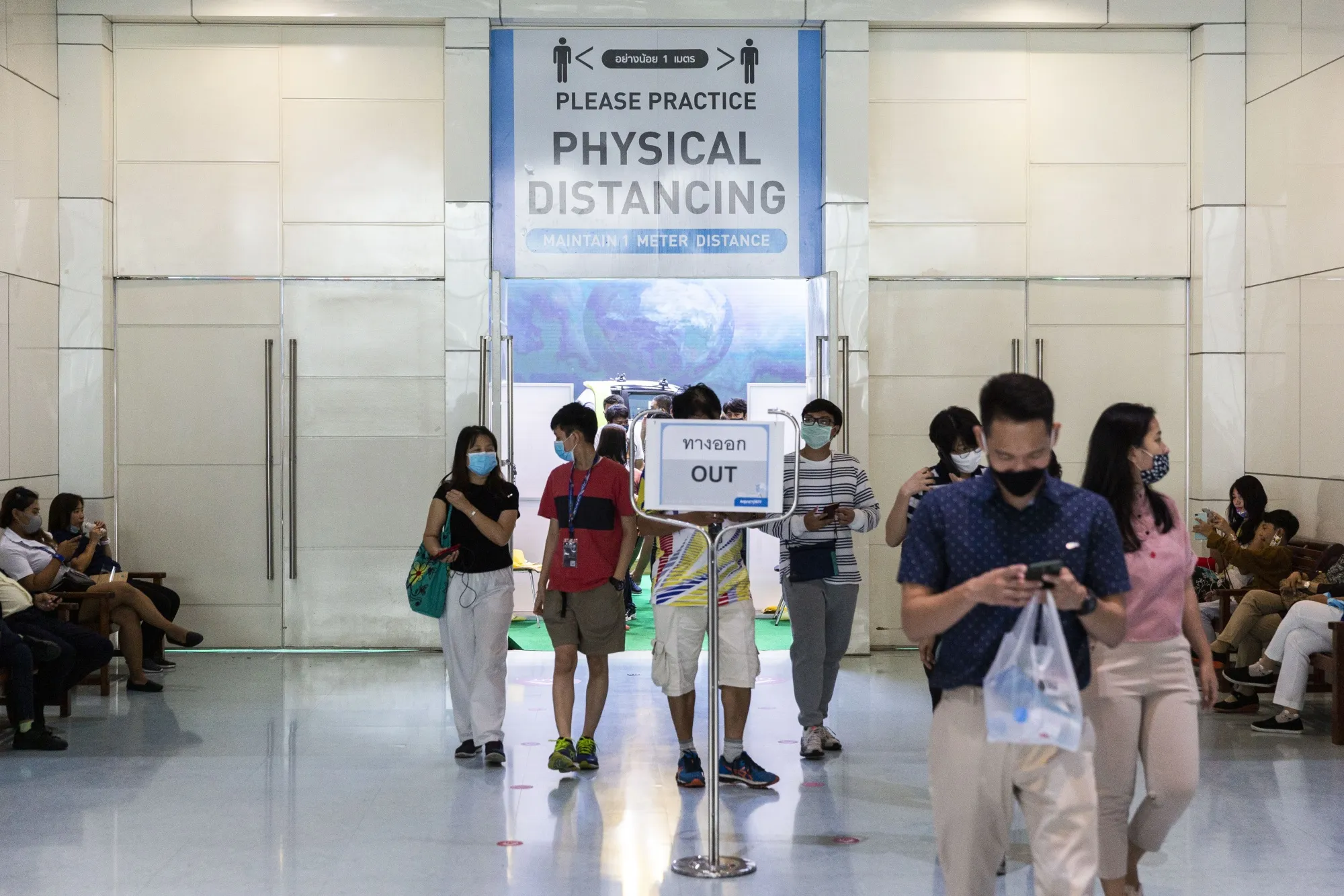 A physical distancing sign is displayed at an exit to the Bangkok International Motor Show in Bangkok, on July 19.