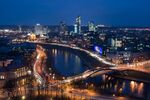Light trails from passing traffic illuminates the River Neris and city skyline in Vilnius.