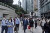 Commuters walk along a sidewalk in the Central district of Hong Kong