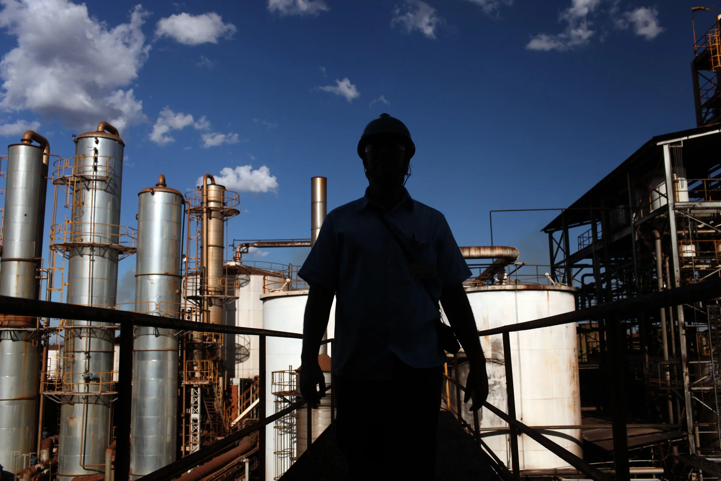 A worker&nbsp;walks next to distilling tanks at the Louis Dreyfus Commodities' Biosev sugarcane processing facility unity near Sertaozinho, Brazil