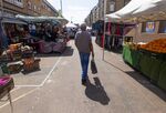 A customer passes between stalls at a street market in London.