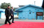 Kim Jong Un, North Korea's leader, left, and Moon Jae-in, South Korea's president, walk along a red carpet together in the village of Panmunjom in the Demilitarized Zone (DMZ).