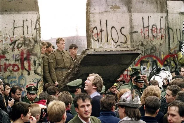 West Berliners crowd in front of the Berlin Wall on Nov. 11, 1989 as East German border guards demolish a section of the wall