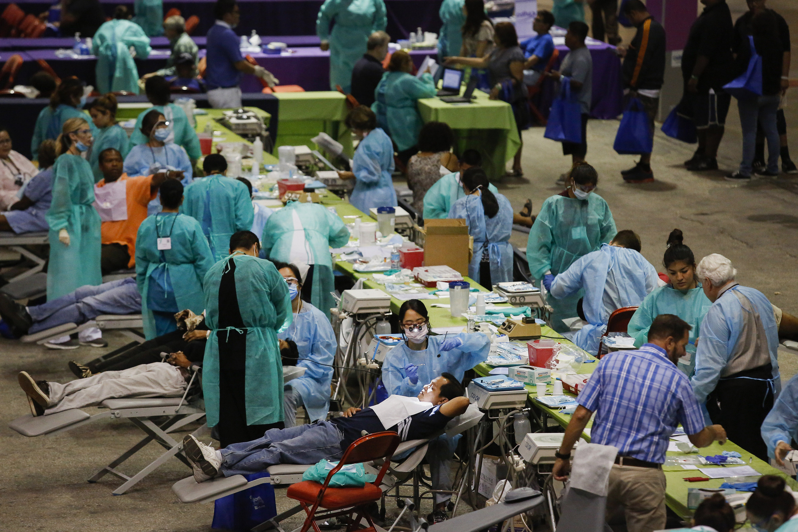 Patients receive dental care during the Care Harbor Public Health Clinic event at the Los Angeles Sports Arena in Los Angeles, California, U.S., on Thursday, September 11, 2014.

