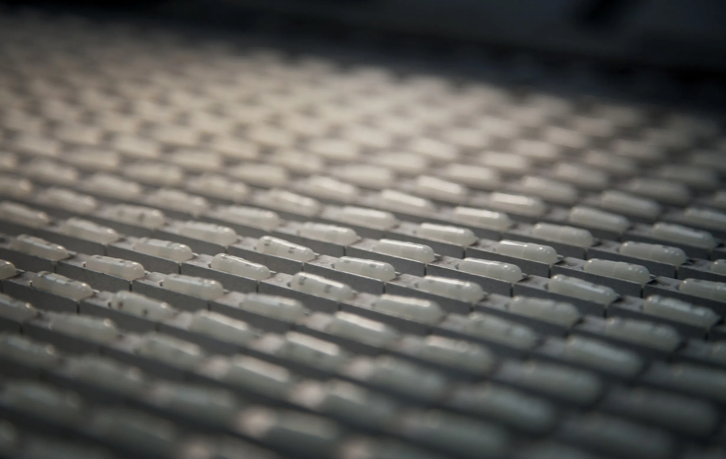 Capsules sit lined up after being printed at a manufactuting plant 