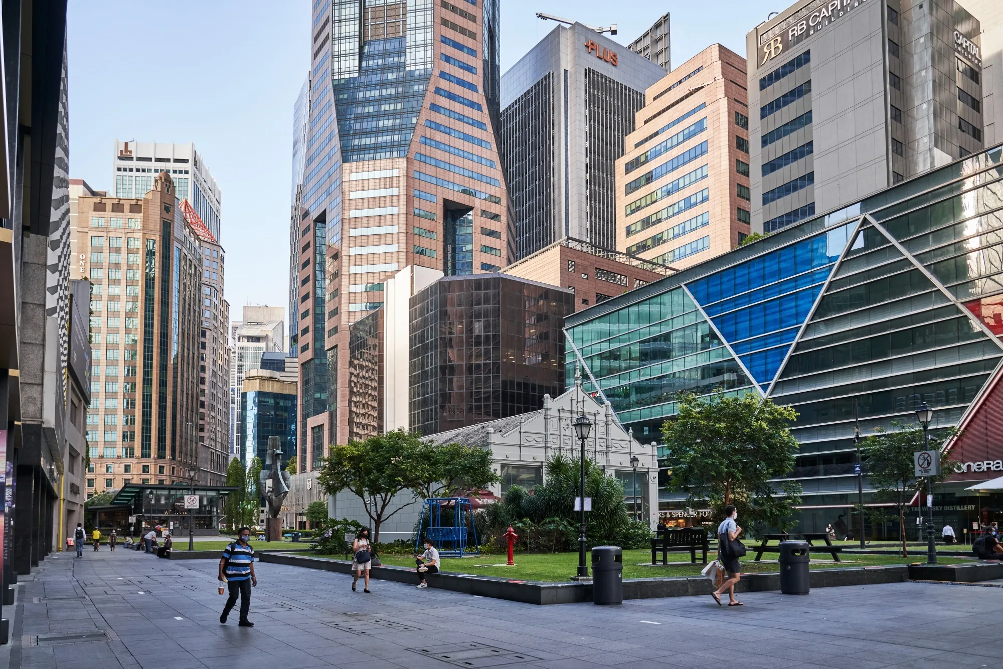 Pedestrians pass through a near empty Raffles Place in the central business district (CBD) of Singapore, on Tuesday, Sept. 28, 2021.&nbsp;