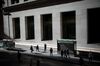 Pedestrians walk along Wall Street near the New York Stock Exchange (NYSE) in New York, U.S., on Friday, March 18, 2016. Shares in developing nations are poised to enter a bull market and the Standard & Poor’s 500 Index erased this year’s losses as gains in oil and favorable shifts in central-bank policies support riskier assets.