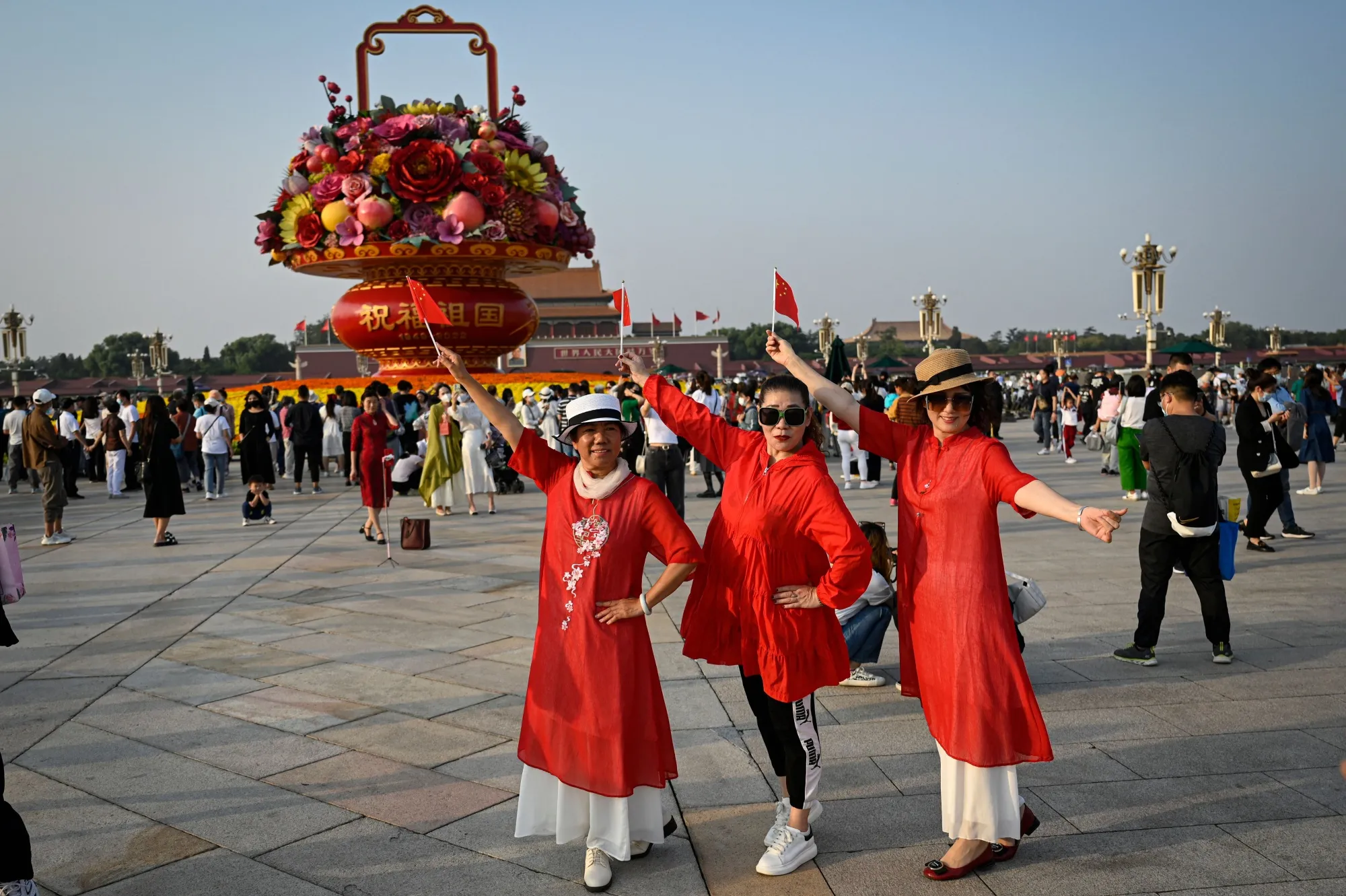 People pose for photos in front of an installation celebrating the upcoming National Day and the 20th Communist Party Congress at Tiananmen Square in Beijing, on Sept.&nbsp;29.