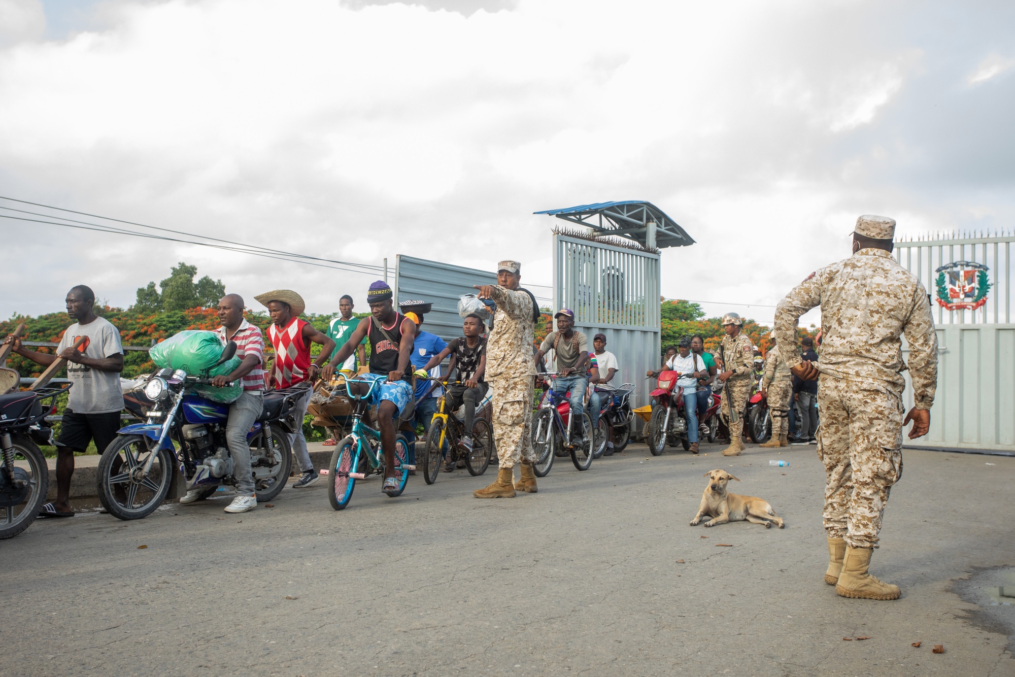 Members of the Specialized Border Security Corps direct pedestrians arriving from Haiti at the Dominican Republic. The Dominican Republic is building a barrier to insulate one of the region’s most successful economies from chaos in Haiti.