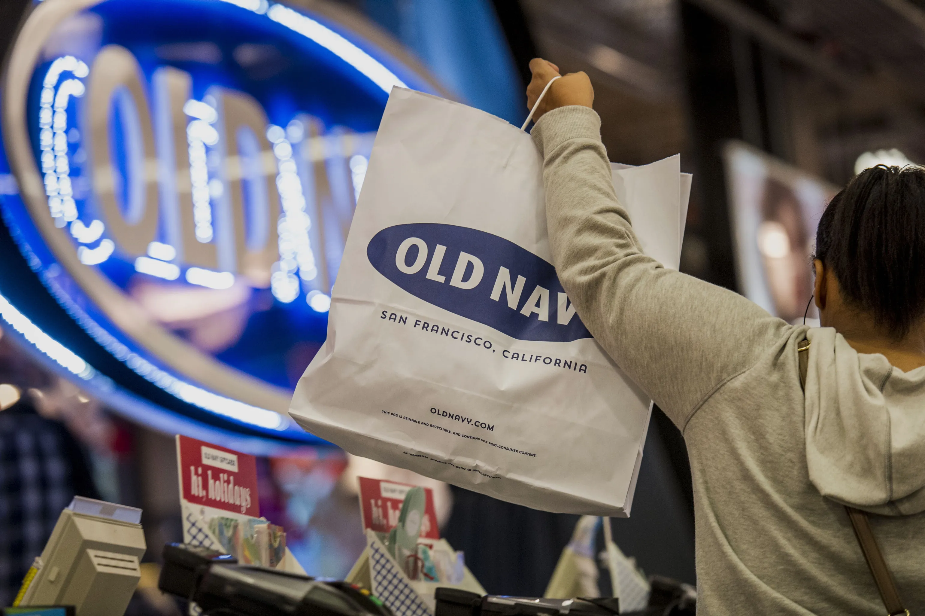 A customer lifts a shopping bag at an Old Navy store in San Francisco.